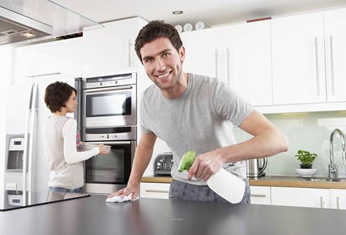 زوجين القيام التنظيف في المطبخ