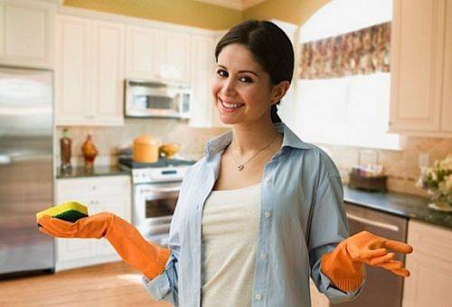žena v kuchyni s gumovými rukavicami