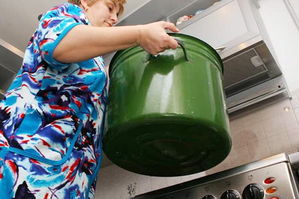 Frau hält Topf zum Kochen von Wäsche