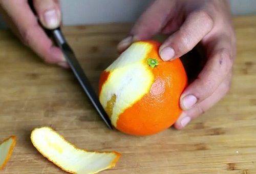 ξεφλουδίζοντας ένα πορτοκάλι με ένα μαχαίρι