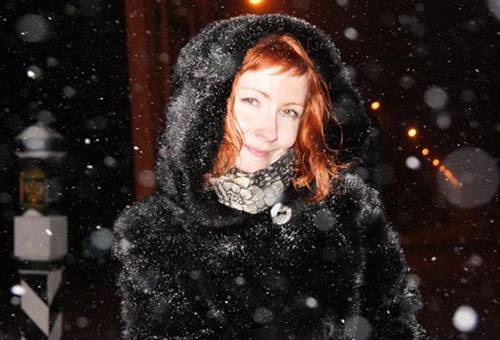 Vrouw in een nertsjas onder een sneeuwval