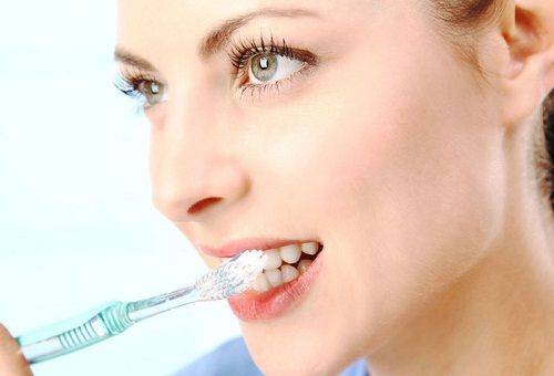 אישה מצחצחת שיניים