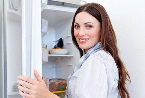 Flickan förbereder sig för att tina upp kylskåpet