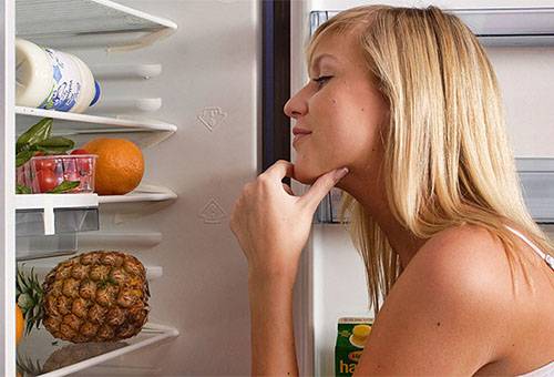 Lány feküdt gyümölcsök és zöldségek a hűtőben