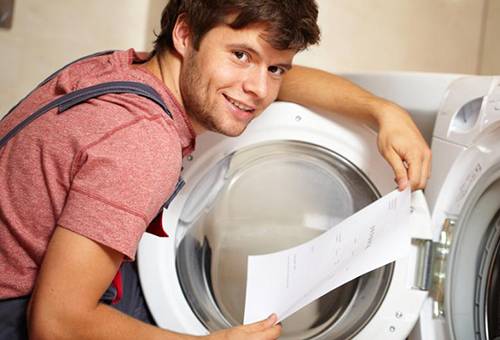En man studerar instruktionerna för tvättmaskinen
