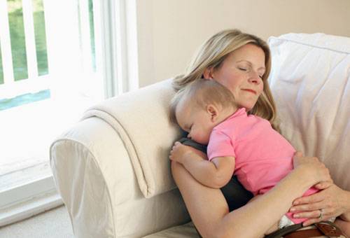אישה עם תינוק על הספה