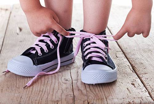 Kind bindende schoenveters op sneakers