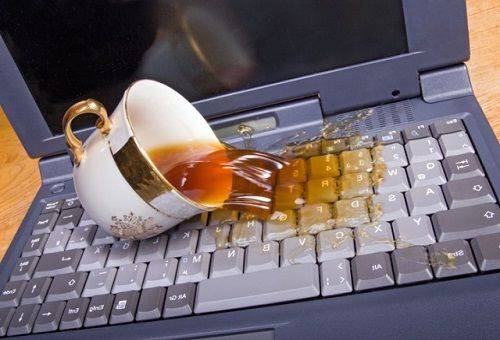 bærbar computer hældes kaffe