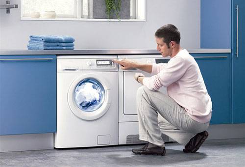 Човек проверява работата на пералня