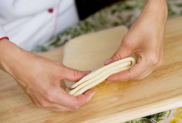 Puff pastry in the hands of the cook
