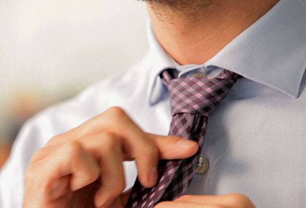 Az ember kiegyenesíti a nyakkendőjét