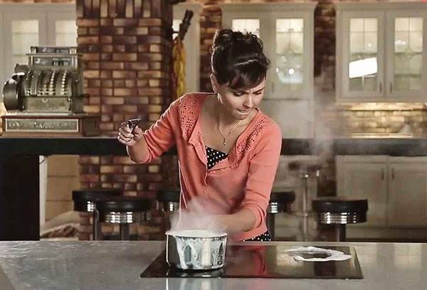Jente lager mat på en keramisk komfyr