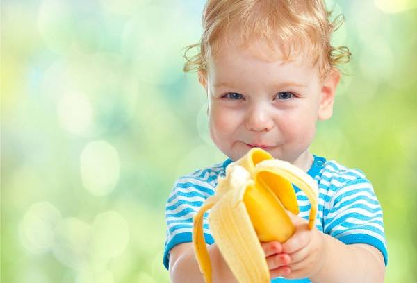 bērns ēd banānu