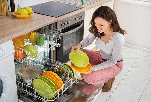 Дјевојка истова машину за прање судова