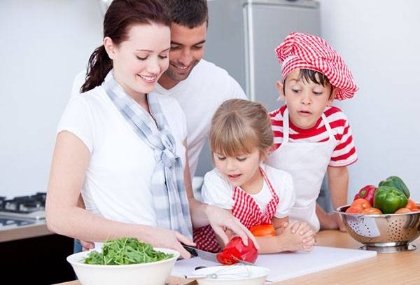 Rodina v kuchyni připravuje salát