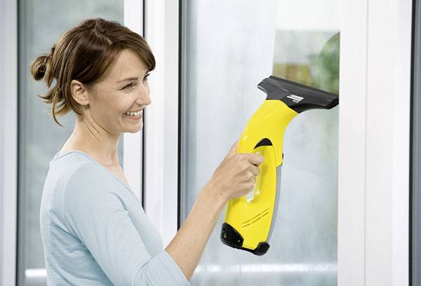 Girl cleans windows dengan Karcher wiper