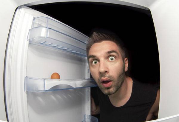 Muž sa pozerá do chladničky