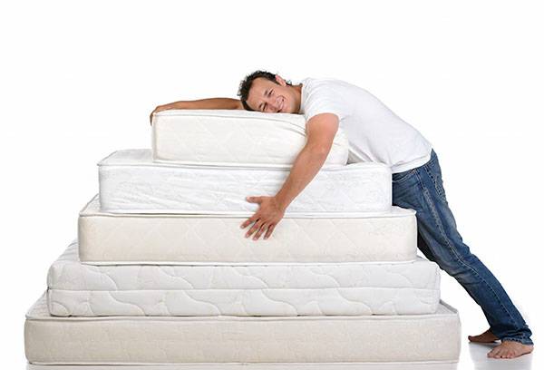 En man med ett berg av madrasser