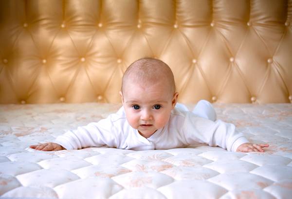 Kūdikis ant didelės lovos