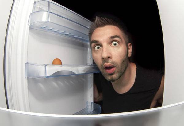 Човек гледа у фрижидер