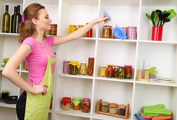 Flickan rensar upp hyllor med livsmedel