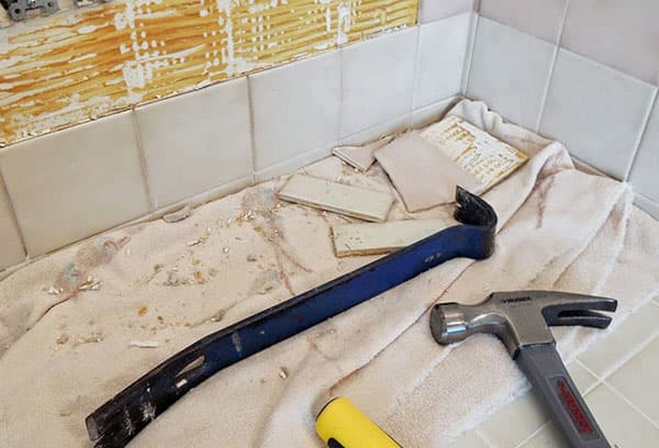 El proceso de desmantelamiento de azulejos viejos en el baño.