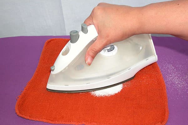 Netejar la sola del ferro amb sal