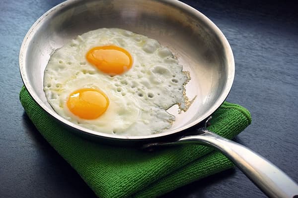 Huevos fritos en una sartén de aluminio.