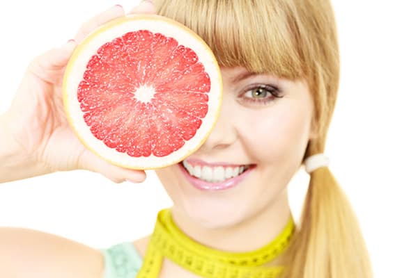 Flicka med grapefrukt