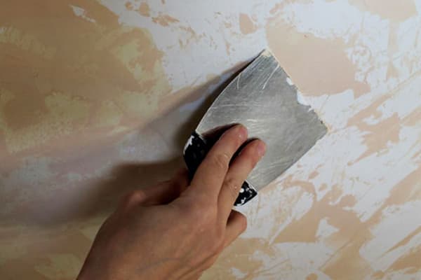 Eliminación de pintura a base de agua con una espátula.
