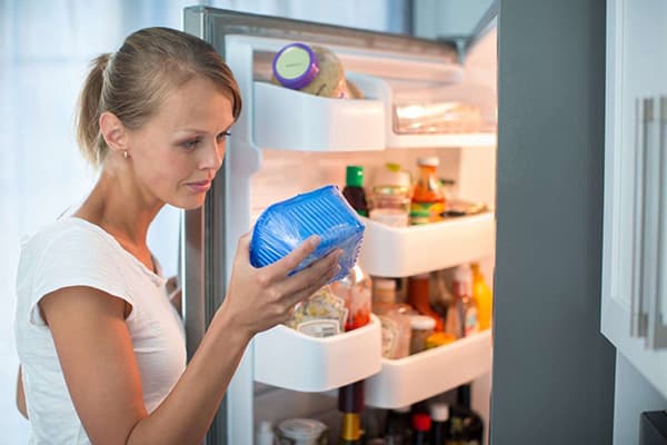 Pigen foretager en revision i køleskabet