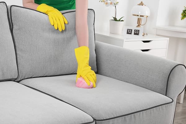 Femeia curăță o canapea