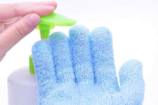 Poner jabón en un guante de lavado