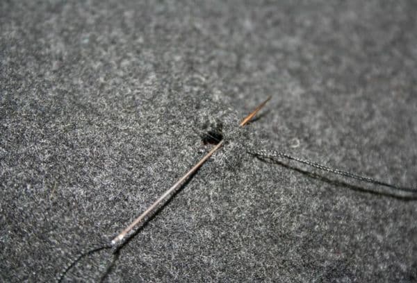 Reparació de roba amb una agulla i fil