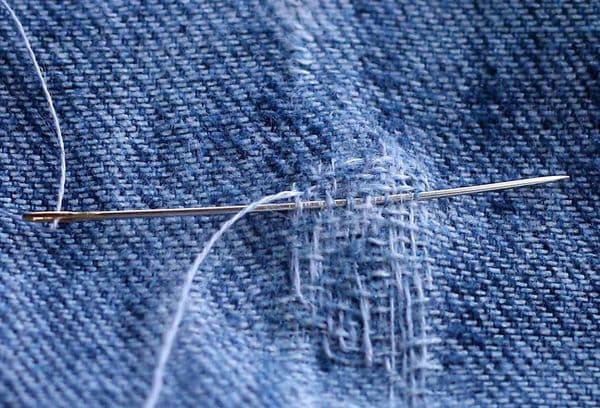 Een gat naaien in een spijkerbroek