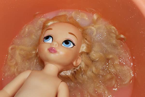 Lavar el cabello de una muñeca con un suavizante de telas