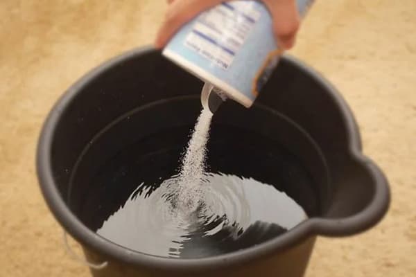 Dodavanje soli u kantu vode