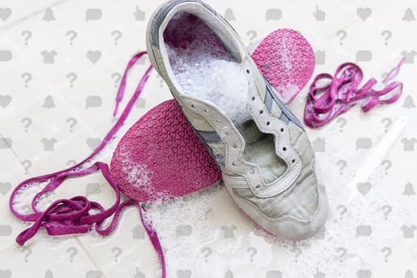 ล้างรองเท้าผ้าใบด้วยสีชมพู laces และพื้นรองเท้า
