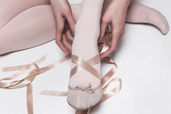 Dievča si oblieka tanečné baletné topánky