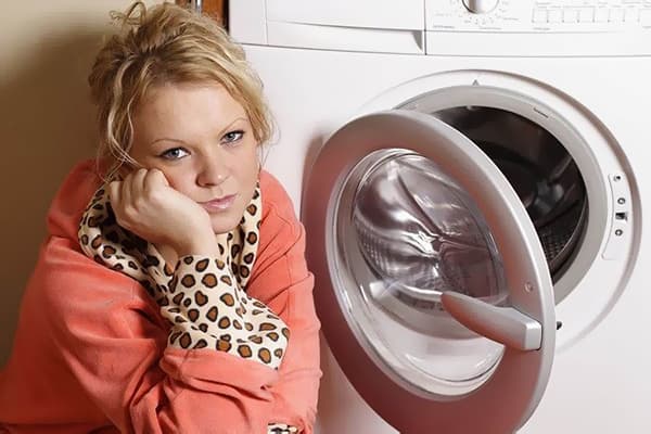 Moteris prie skalbimo mašinos