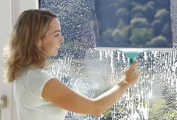 Mädchen wäscht ein Fenster