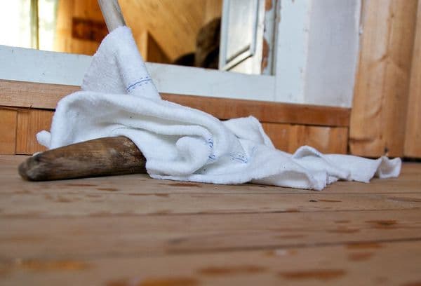 moppar golvet med en handduk