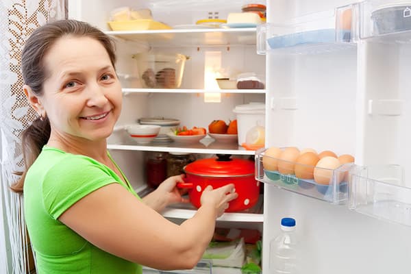 La donna mette la padella in frigorifero