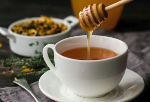 Menambah madu untuk teh panas