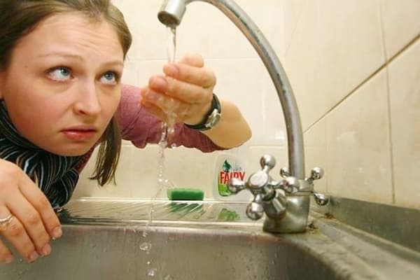 Kvinnan undersöker kranvatten