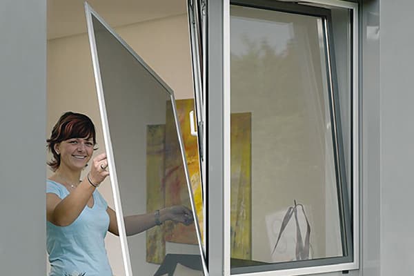 Vrouw verwijdert het net uit het raam