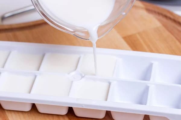 Nalievanie mlieka na formy na ľad