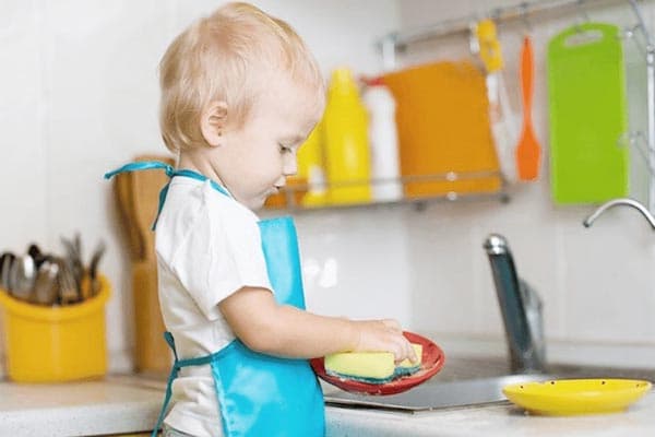 Bērns mazgā traukus