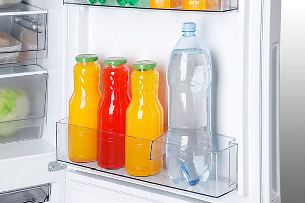 Gėrimai ant šaldytuvo durų lentynos