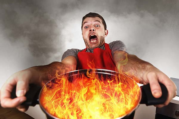 Een man met een brandende pan